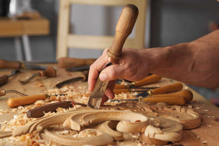 Woodworking tools. Carving wood with chisel. Carpenters hands use chieselの写真素材