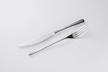 Stylish classy elegant metallic eating knife and fork cutlery for dining kitchen utensils Isolated on a white background, well lit. Kitchen set Flatware on white.の写真素材