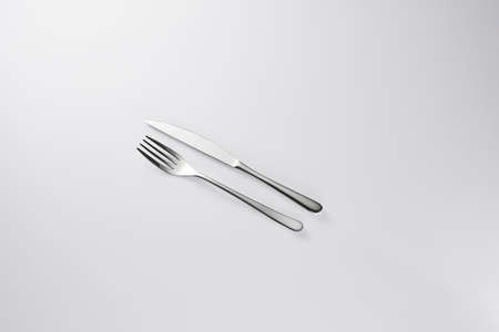 Stylish classy elegant metallic eating knife and fork cutlery for dining kitchen utensils Isolated on a white background, well lit. Kitchen set Flatware on white.の写真素材