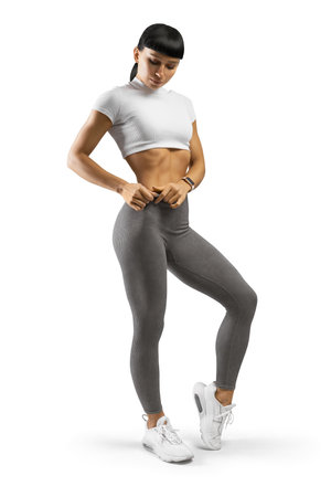 Young fitness woman in white and grey sporty lingerie isolated on whiteの写真素材