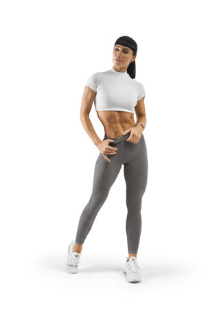 Perfect sensual female body. Fit Woman style with sexy hips. Female with perfect abdomen muscles. Beautiful Body in sport clothes isolated on whiteの写真素材