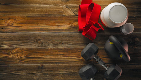 Fitness equipment and supplements top view on wooden floor copy free space. Mock-up. Sports bodybuilding supplements and nutrition.の写真素材