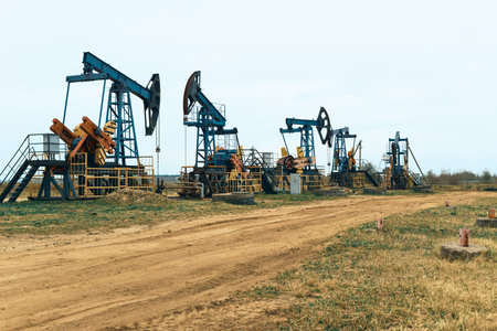 Oil Pump Jacks. Country road and Oil pumps, nodding donkey or pump jack and rig.の写真素材