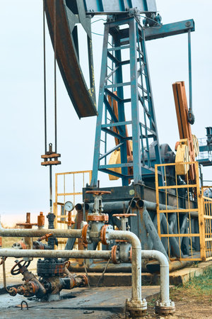 Oil Pump Jacks. Country road and Oil pumps, nodding donkey or pump jack and rig.の写真素材