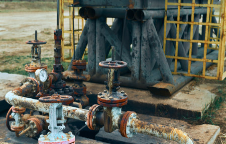 Close-Up Of Valve On Pipeline. Oil Or Gas Transportation With Gas Or Pipe Line Valves On Soil And Sunrise Background. Valve pipes, turn off on gas pump vent.の写真素材