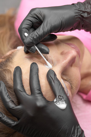 Eyebrow permanent make-up. Woman Having Permanent Make-up Tattoo on her Eyebrows. Closeup beautician doing tattooing eyebrow. Professional makeup and cosmetology skin care.の写真素材