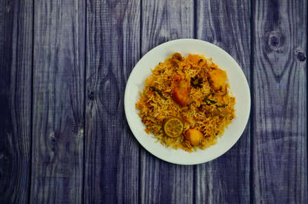 A Presentation of  Restaurant Style Karachi Chicken Biryani with Potatoes made in Sella rice in White Plateの写真素材