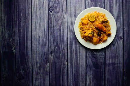 A Presentation of  Restaurant Style Karachi Chicken Biryani with Potatoes made in Sella rice in White Plateの写真素材