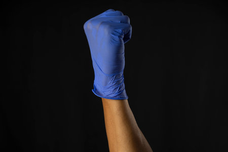 Hand in blue medical glove on black background, closeup. Space for textの写真素材