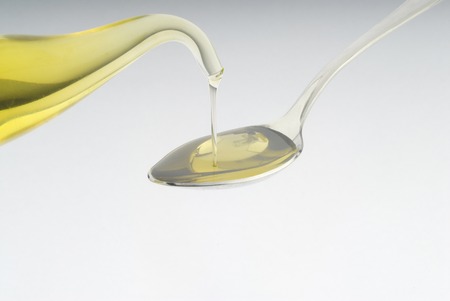 oil pouring into a spoonの写真素材