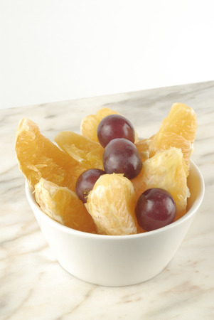 Bowl with orange slices and grapesの写真素材
