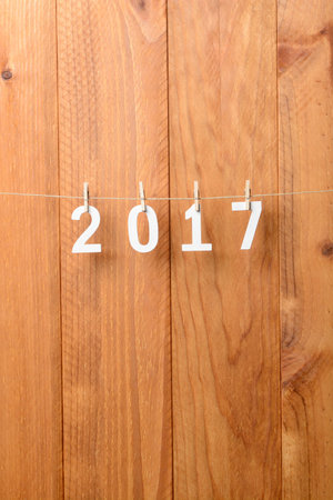 2017 written in wooden letters hanging from a rope, New Year