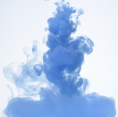 Blue ink petering out in water, white backgroundの写真素材