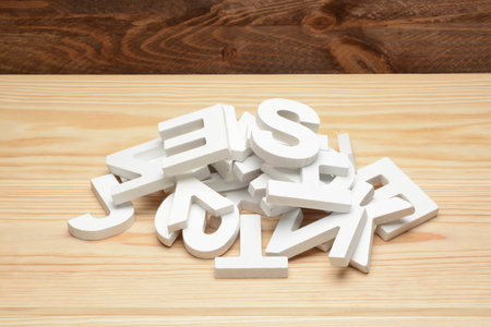 Heap of letters of the alphabet of wood on brown wooden background