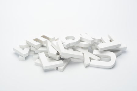 Heap of letters of abcedary wood on white backgroundの写真素材
