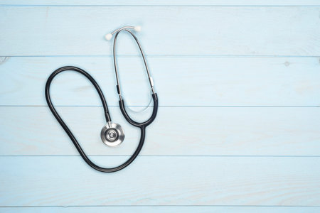 Phonendoscope on blue wooden background, concept of health and medicine