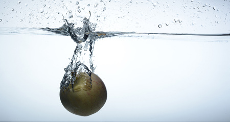 Red apple falling in water, composition as a backgroundの写真素材