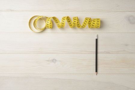 Pencil and tape measure for tailor on white wooden backgroundの写真素材