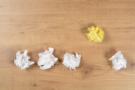 Crumpled balls of paper on brown wood background, idea coceptの写真素材