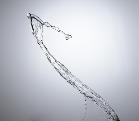 Moving water on white background, jets and dropsの写真素材