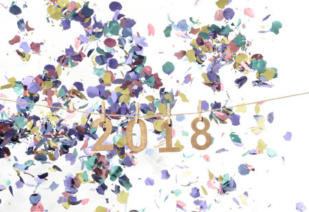 New year 2018 in numbers of golden wood hanging on a rope and confetti