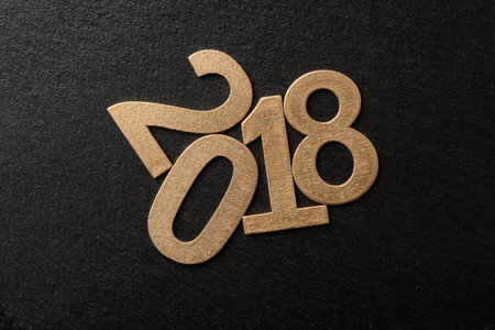 New year two thousand and eighteen in golden wood letters on wooden background, 2018
