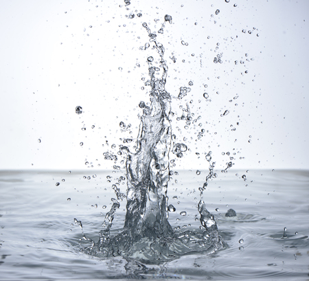Moving water on white background, jets and dropsの写真素材