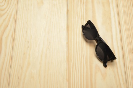 Black sunglasses on the wooden floorの写真素材