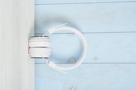 Helmets or headphones on a white wooden table and blue wallの写真素材