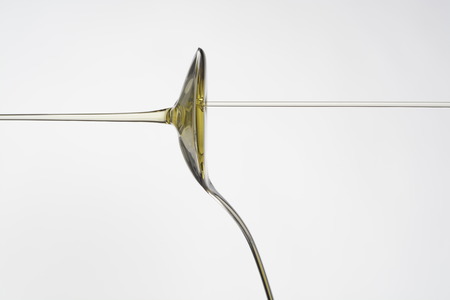 Oil dropping or pouring into a spoonの写真素材