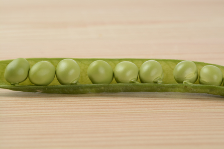 Raw peas on the wooden tableの写真素材