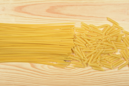 Raw pasta on a wooden table, idea or conceptの写真素材