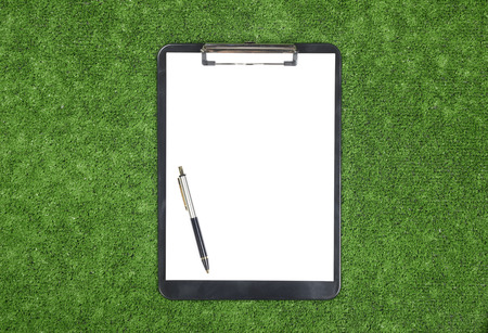 Table or notebook with pen on artificial grassの写真素材