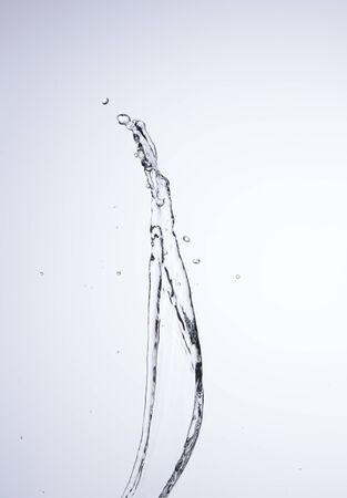 Moving water on white background, jets and dropsの写真素材