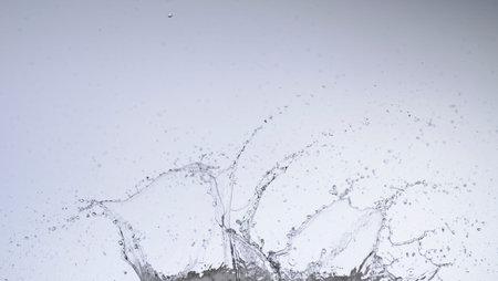 Moving water on white background, jets and drops