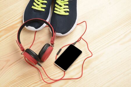 Phone, headphones and sneakers on the wooden floorの写真素材