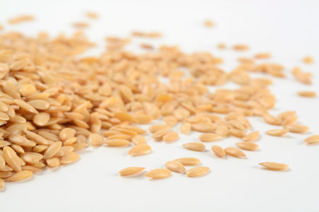Golden flax seeds on white background, detail