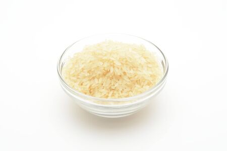 Raw long steamed rice in a glass bowl on white backgroundの写真素材