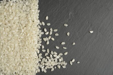 White round rice on a black stone background, balck and white colorsの写真素材
