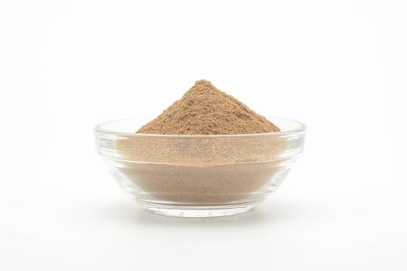 Ground cinnamon in a glass bowl on white backgroundの写真素材