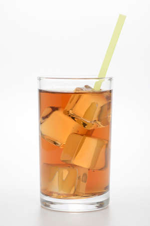 Glass of iced tea on white background with green strawの写真素材