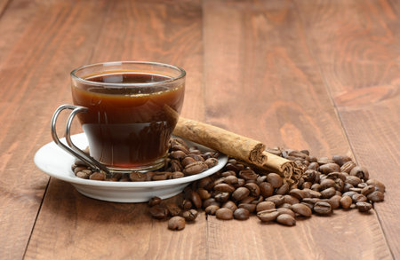 Coffee in a cup and coffee beans on the tableの写真素材