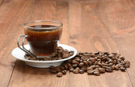 Coffee in a cup and coffee beans on the tableの写真素材