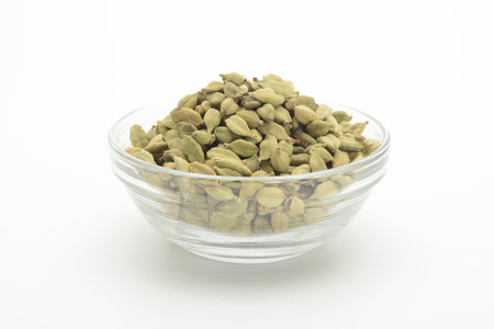 Cardamom in a transparent glass bowl on white backgroundの写真素材