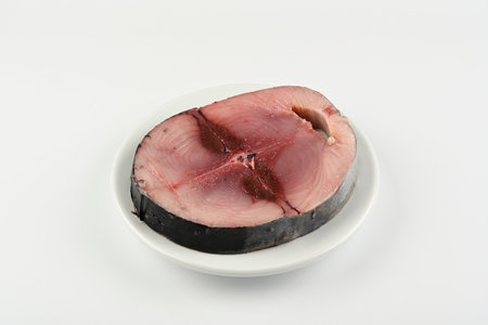 Slice of fresh bonito on a plate on white backgroundの写真素材