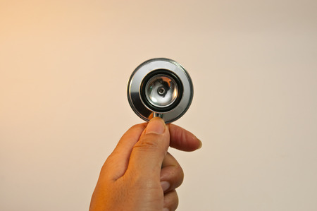 Hand is holding stethoscope with white backgroundの写真素材
