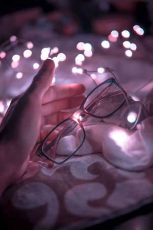 Decorating house by beautiful colorful lights for biggest festival, holding eye glass in handの写真素材