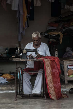 Patna, India- January 21, 2020: Street life and portraits from Calcutta.More than 5 million people live in the city.This man earn a living by tailoringのeditorial素材