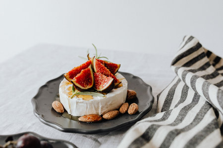 Camembert cheese with white mold, fresh figs, almond and honey on a white background.の写真素材