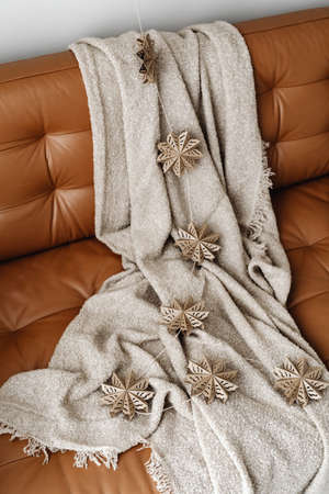 Christmas star kept on brown sofa with white cloths.の写真素材